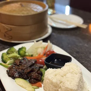 a plate of rice, beef, and vegetables