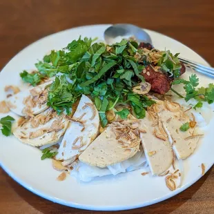 a white plate with chicken, rice and garnish