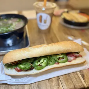 Xá xíu bánh mì with roasted pork belly, pickled carrots, cucumbers, cilantro, and house made mayo