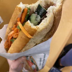 a person holding a sandwich