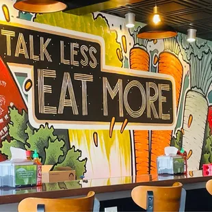 a restaurant with a mural on the wall
