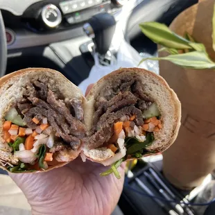 a person holding a sandwich