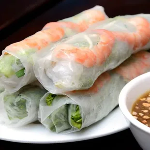 a plate of vietnamese spring rolls with dipping sauce