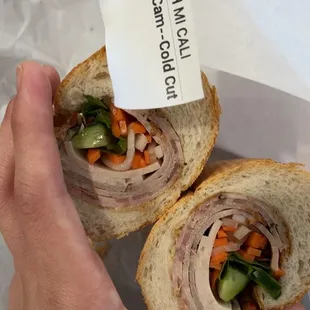 a person holding a sandwich