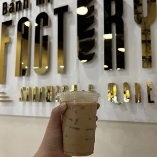 a hand holding a cup of iced coffee