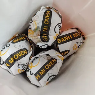 three wrapped chocolates in a paper bag