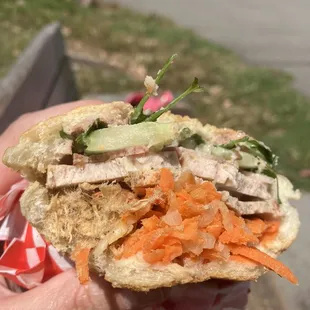 a person holding a sandwich