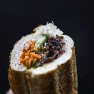 a hand holding a sandwich