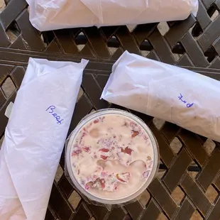 three wrapped sandwiches on a table
