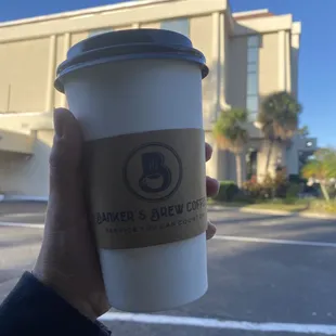 a hand holding a coffee cup