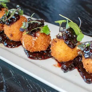  three fried donuts with blueberry sauce