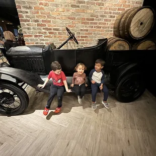  three children sitting on a car
