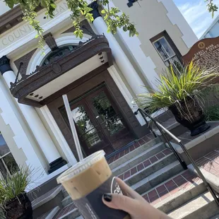 a hand holding a cup of coffee