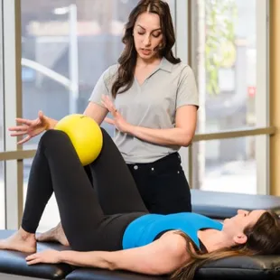 Therapist instructing patient on ball squeeze exercise