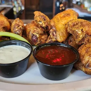 a plate of chicken wings with dipping sauce