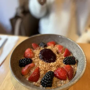 a bowl of oatmeal with strawberries and blackberries