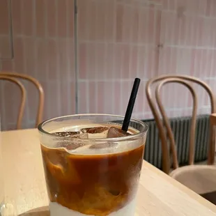 a glass of iced coffee on a table