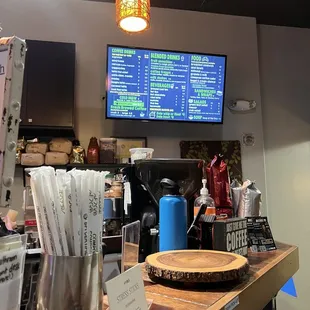 a restaurant counter with a menu on the wall