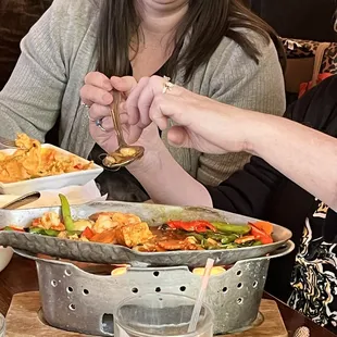 two women sitting at a table with food