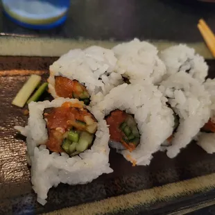 a plate of sushi with chopsticks