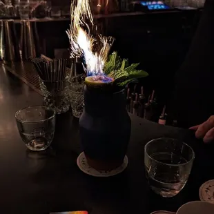 a person lighting a candle on a table