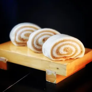 three rolls on a wooden stand