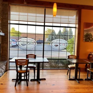 a table and chairs in front of a large window