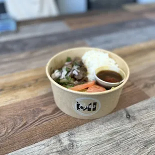 a bowl of food on a wooden table