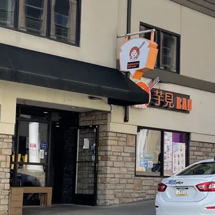 a white car parked in front of a chinese restaurant