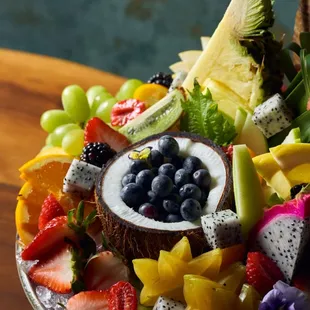 a fruit platter with fruit and a coconut