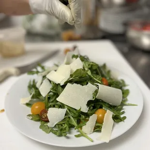 a plate of salad with parmesan cheese