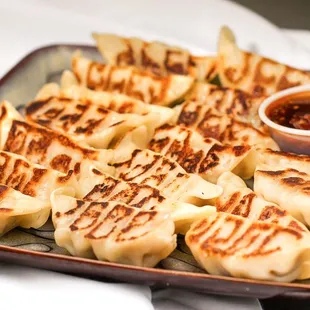 a plate of dumplings with dipping sauce