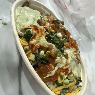 Steak, cilantro lime rice, black beans, cilantro sauce, hot sauce, cucumber slices, shredded cheese, pico de gallo, &amp; corn.
