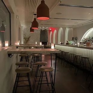 a row of bar stools in a dimly lit room