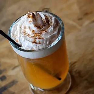 a glass of beer with whipped cream on top