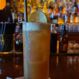 a cocktail with a lime slice