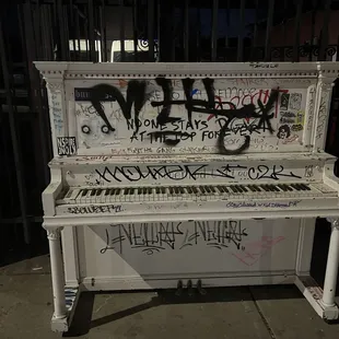 a white piano covered in graffiti