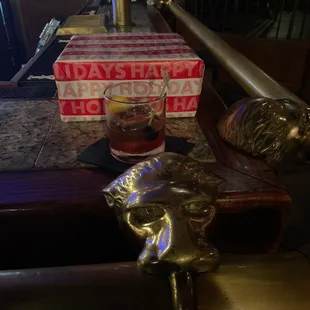 a glass of whiskey and a statue of a lion