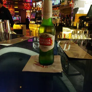 a bottle of beer on a bar counter