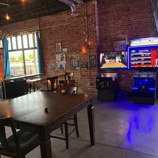 tables and chairs in a room with brick walls
