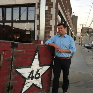 a man leaning against a fence with a star painted on it
