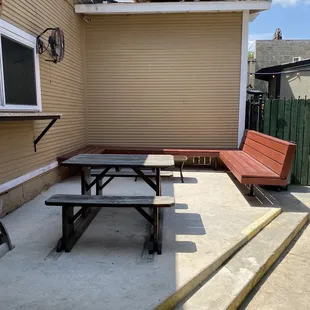 a patio with a bench and table