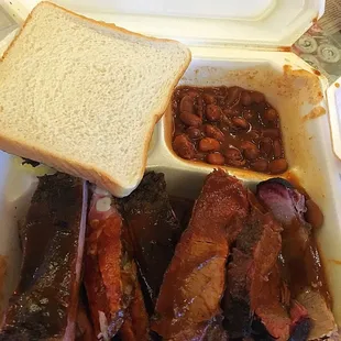 ows ribs, beans, and bread in a styrofoam container