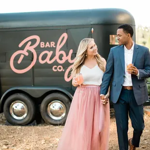 a man and woman walking in front of a food truck