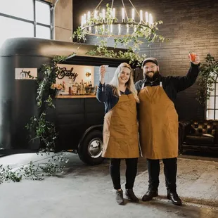 two people standing in front of a food truck