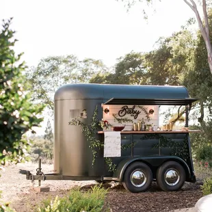 a food truck parked in front of a tree