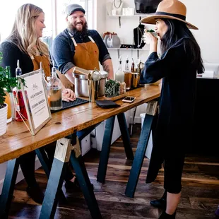 two women and a man at a bar