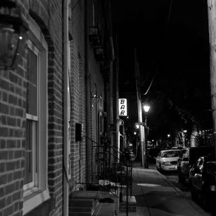 a black and white photo of a street at night