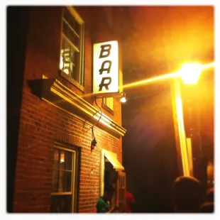 a brick building at night with a neon sign