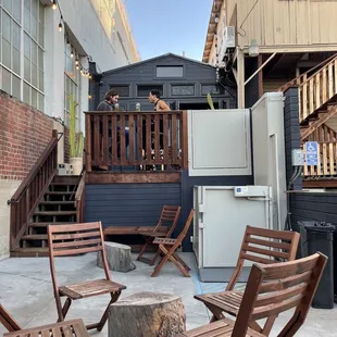 a patio with wooden chairs and a fire pit